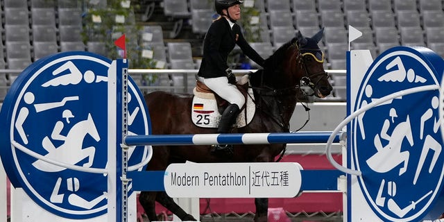 Annika Schleu of Germany cries as she couldn't controls her horse to compete in the equestrian portion of the women's modern pentathlon at the 2020 Summer Olympics, Friday, Aug. 6, 2021, in Tokyo, Japan. 